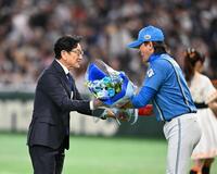 新庄監督（右）から花束を受け取る栗山英樹氏（撮影・堀内翔）