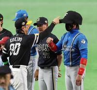 巨大キャップをかぶった新庄監督をいじる小久保監督（撮影・山口登）
