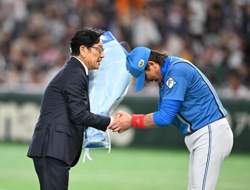 新庄監督（右）から花束を受け取る栗山英樹氏（撮影・堀内翔）