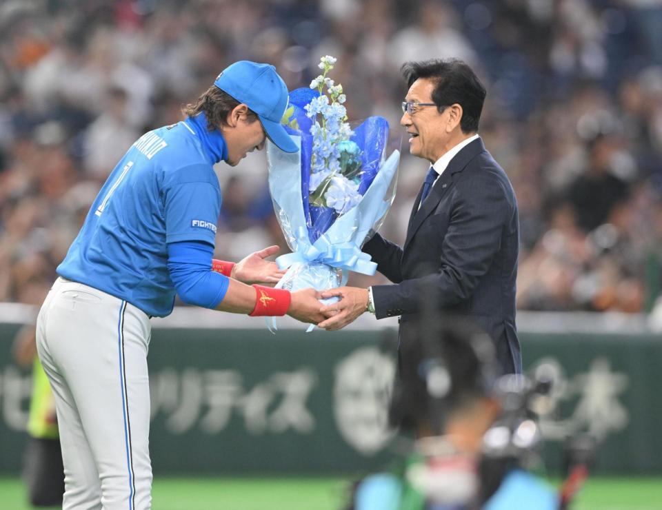 野球殿堂入り表彰式で新庄監督（左）から花束を受け取り感激の栗山英樹氏（撮影・開出牧）