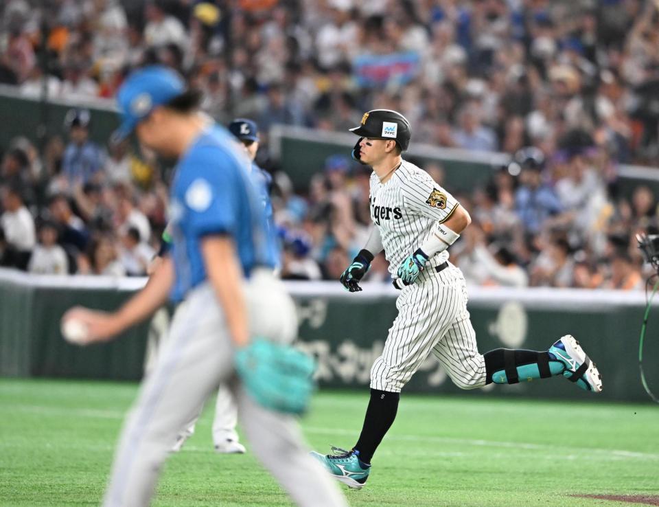 １回、ソロを放ち一塁を回る佐藤輝。手前左は伊藤（撮影・堀内翔）