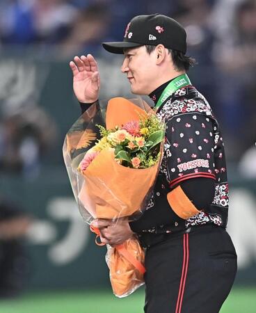 通算２０００試合出場達成の表彰で花束を受け取り笑顔の丸（撮影・開出牧）