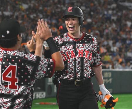 １回、先制の左越えソロを放ちナインとタッチを交わす松本（撮影・開出牧）
