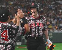 １回、先制の左越えソロを放ちナインとタッチを交わす松本（撮影・開出牧）