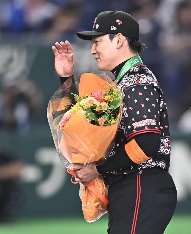 通算２０００試合出場達成の表彰で花束を受け取り笑顔の丸（撮影・開出牧）