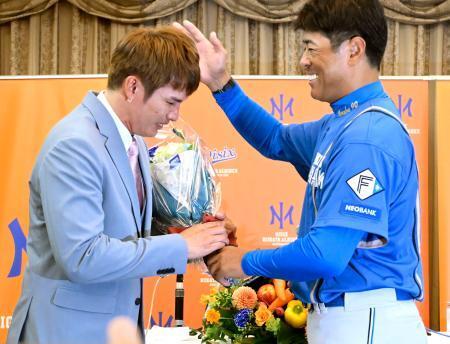 　日本ハムの稲葉２軍監督（右）から花束を受け取り、涙ぐむオイシックスの陽岱鋼外野手＝１日、新潟市