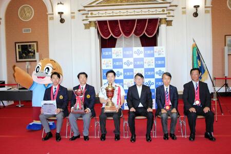 記念写真に収まる（左から）もずやん、関大・大田マネジャー、森内主将、吉村知事、高岡専務理事、北原顧問、小田監督