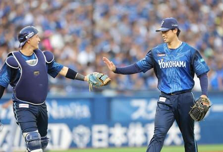 ２回、無失点に抑え、松尾（左）とタッチを交わす尾形（撮影・西岡正）