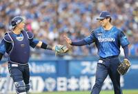２回、無失点に抑え、松尾（左）とタッチを交わす尾形（撮影・西岡正）