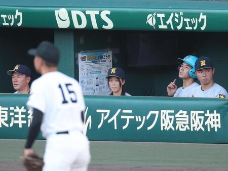 記録員としてベンチに入り、グラウンドを見つめる仙台育英・星よつはさん（中央）