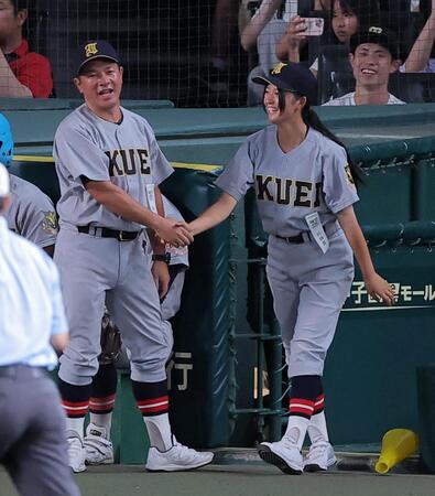 初戦に勝利し、仙台育英・須江航監督（左）と笑顔で握手をする仙台育英・星よつはマネージャー（撮影・西田忠信）