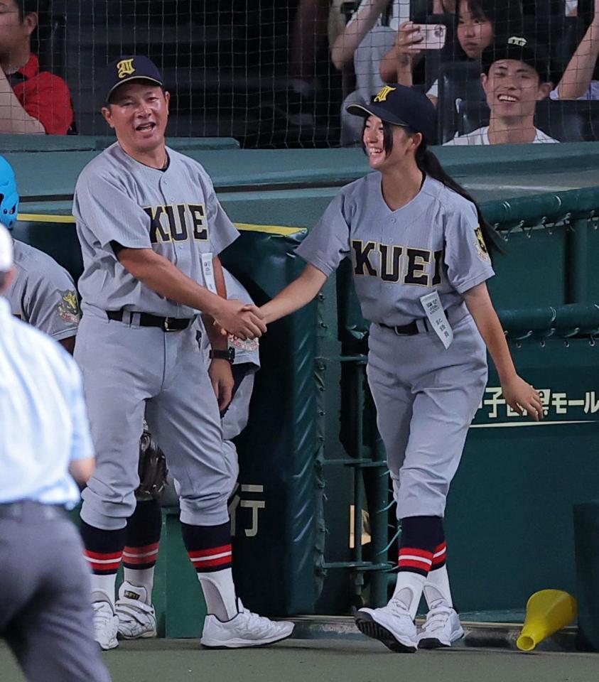 初戦に勝利し、仙台育英・須江航監督（左）と笑顔で握手をする仙台育英・星よつはマネージャー（撮影・西田忠信）