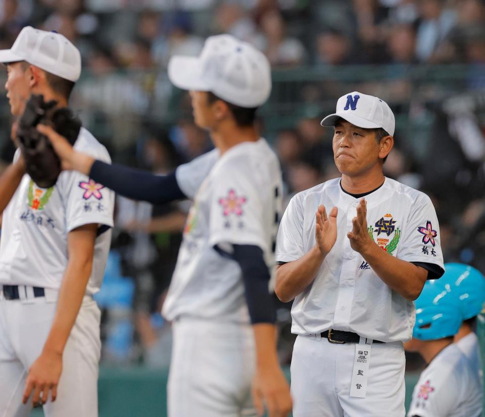 初回の守備を終えたナインを迎える佐野日大・麦倉洋一監督＝甲子園（撮影・西田忠信）