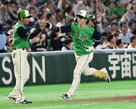 ７回、先制ソロを放ちコーチとタッチする長岡（右）