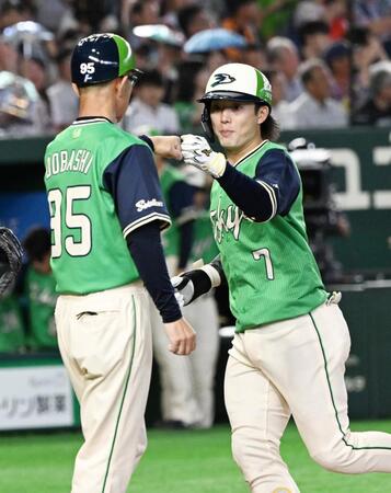 ７回、先制ソロを放ち土橋コーチ（左）に迎えられる長岡