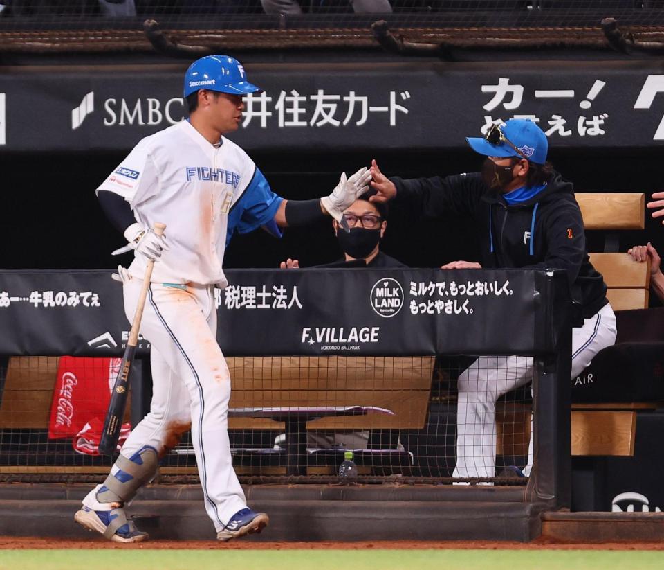 ８回、中前打を放った吉田（左）を迎える新庄監督（撮影・中島達哉）