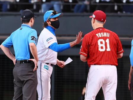 メンバー表を交換の際に吉井監督（右）に手で「５」を示す新庄監督（中央）＝撮影・中島達哉