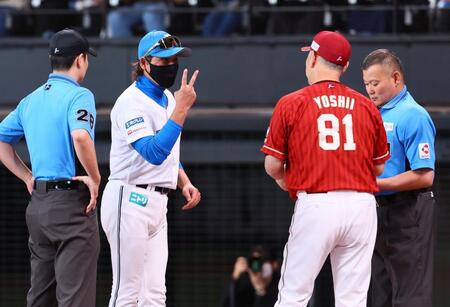 メンバー表を交換の際に吉井監督（８１）にピースサインを示す新庄監督（中央）＝撮影・中島達哉
