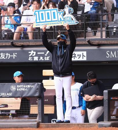３回、通算１０００奪三振を達成した有原の記念ボードを掲げる新庄監督（撮影・中島達哉）