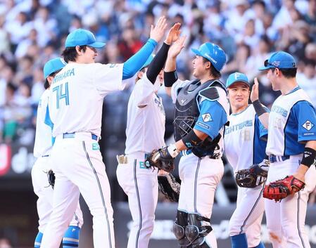 完封勝利をあげ、進藤（中央）らナインとタッチを交わす有原（左）＝撮影・中島達哉