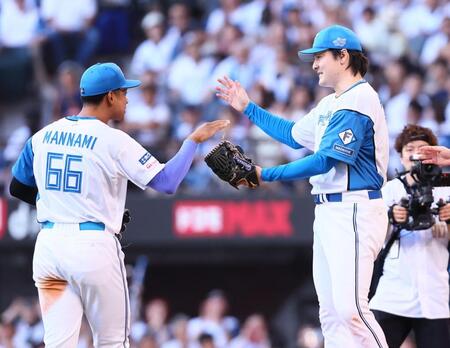完封勝利をあげ、万波（左）からウイニングボールを受け取る有原（撮影・中島達哉）