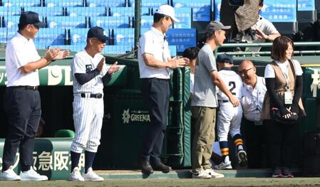始球式を務めた少年（２）に笑顔で拍手を送る明徳義塾・馬淵史郎監督（左から２人目）＝撮影・高部洋祐