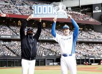 　通算１０００奪三振を達成し、新庄監督（左）と記念ボードを掲げる有原（球団提供）