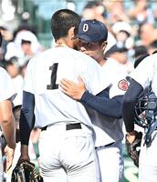 試合後の整列を終え横浜・織田翔希（１）と抱き合う沖縄尚学・末吉良丞（撮影・開出牧）