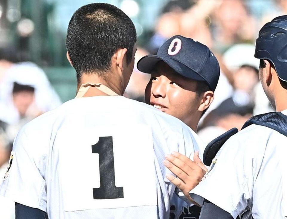 試合後の整列を終え横浜・織田翔希（１）と抱き合い健闘をたたえ合う沖縄尚学・末吉良丞（撮影・開出牧）