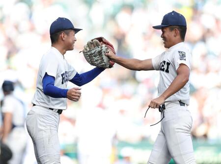 １回、享栄・永谷陽翔の打球を処理し、本塁に好返球を見せた竿谷凛斗（右）を笑顔で迎える履正社・木村颯（撮影・中田匡峻）