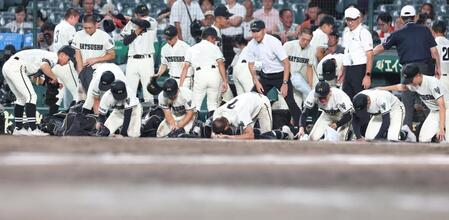 三重に敗れ、涙ながらに砂を集める松商学園ナイン（撮影・中田匡峻）