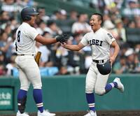 ４回の攻撃を終え、笑顔でベンチに戻る履正社・高津冬真（右）＝撮影・中田匡峻