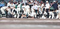 三重に敗れ、涙ながらに砂を集める松商学園ナイン（撮影・中田匡峻）