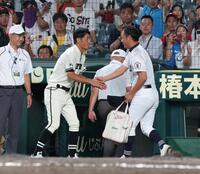 試合後、握手を交わす三重・沖田展男監督（右）と松商学園・松宗勝監督（撮影・中田匡峻）