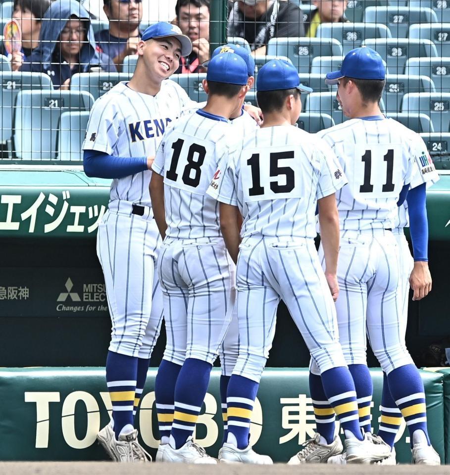 試合前、チームメイトと肩を組み笑顔を見せる健大高崎・石垣聡志（左）＝撮影・開出牧