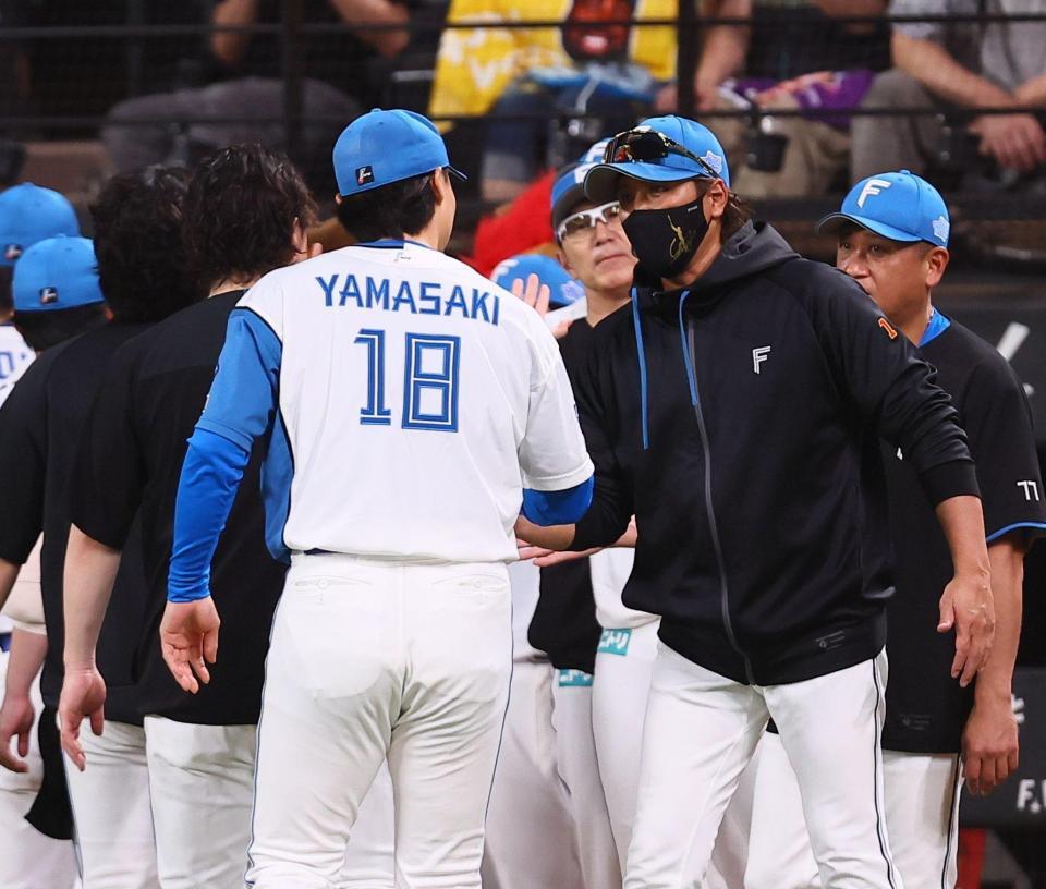 山崎（１８）らナインを迎える新庄監督（撮影・中島達哉）