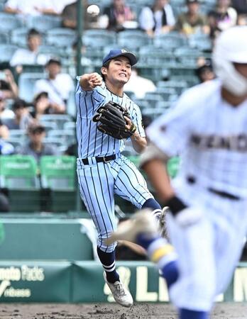 　１回、石田雄の送りバントをジャンピングスローで処理する東海大甲府・田中楓（撮影・開出牧）