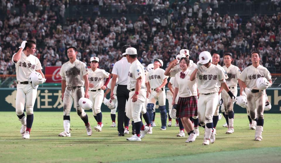 応援スタンドにあいさつを終え引き揚げる日南学園ナイン