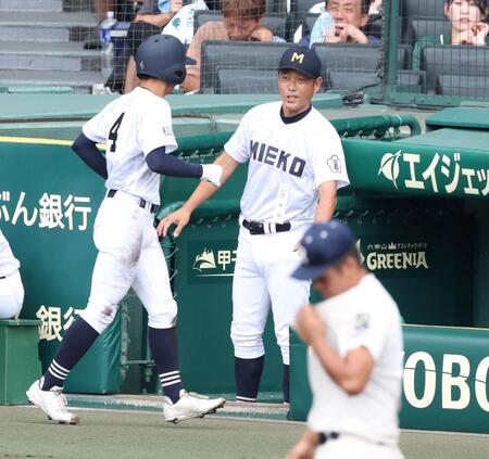 １回、履正社・三木大亮の悪送球で先制の生還を果たした三重・水野央清（左）を迎える三重・沖田展男監督（撮影・中田匡峻）