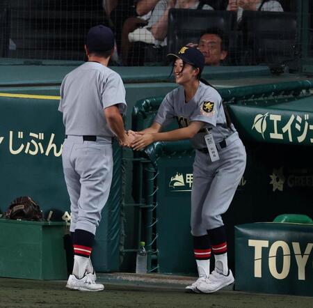 拓大紅陵に勝利し、仙台育英・須江航監督（左）と握手を交わす星よつはマネジャー（撮影・中田匡峻）