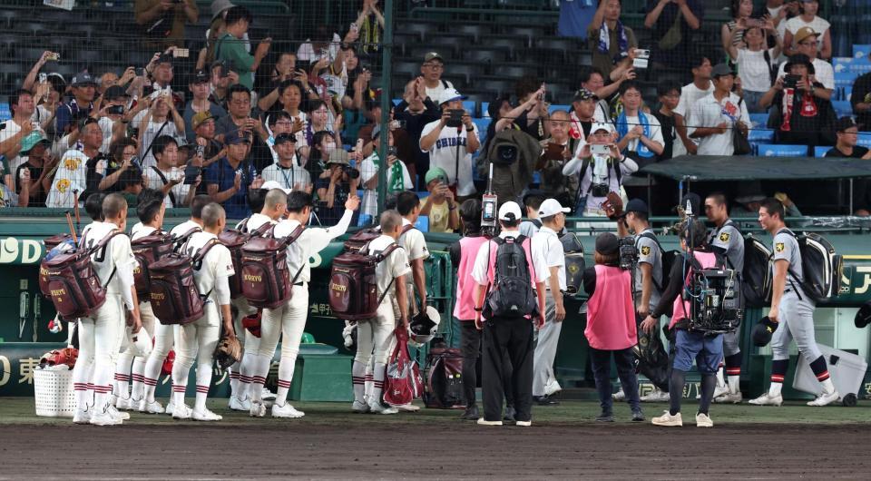 引き揚げる仙台育英ナインを見送る拓大紅陵ナイン（左）＝撮影・中田匡峻