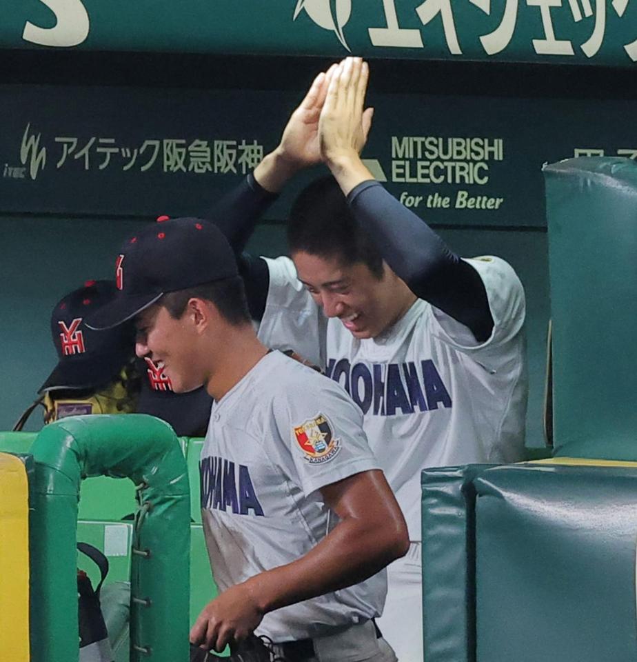 日南学園戦の７回、味方の適時打に手を挙げて喜ぶ織田（撮影・西田忠信）＝１４日