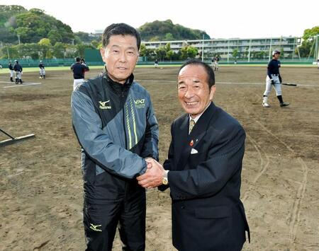 横浜高校野球部のグラウンドで山下智茂氏（右）と握手を交わす渡辺元智さん＝２０１６年４月