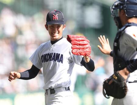 ５回を投げ終え、笑顔で捕手の脇山魁音（右）とタッチをかわす横浜・織田翔希（撮影・中田匡峻）