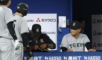 ９回、泉口のプロテクターを修理するウィーラーコーチ（左）とその様子を見つめる橋上監督代行（撮影・伊藤笙子）
