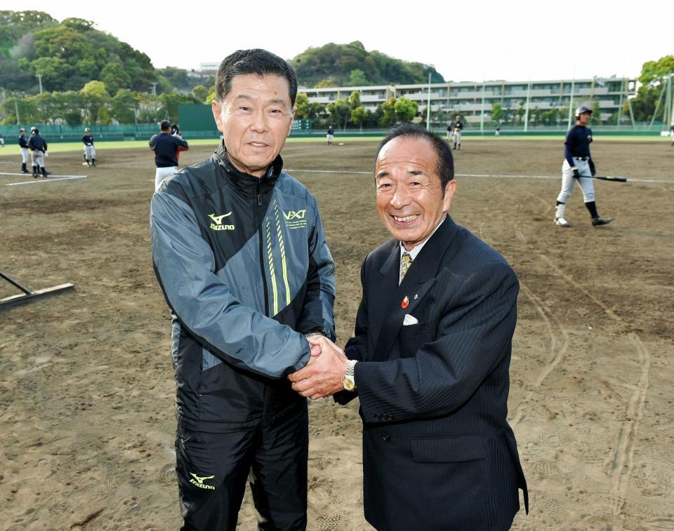 横浜高校野球部のグラウンドで山下智茂氏（右）と握手を交わす渡辺元智さん＝２０１６年４月