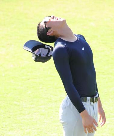 ストレッチで首をそらす横浜・織田翔希は帽子が脱げ苦笑い（撮影・坂部計介）