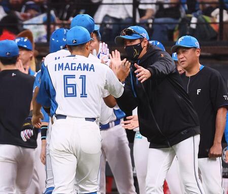 今川（６１）を迎える新庄監督（撮影・中島達哉）