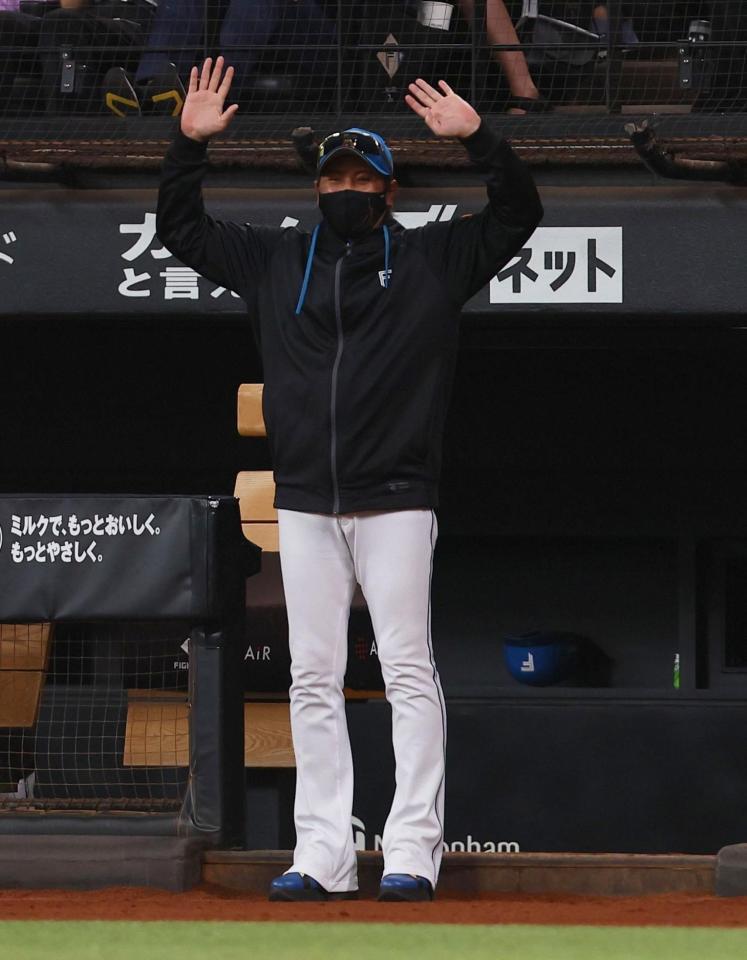 日本ハム・藤森海斗の父の藤森塁さんが始球式を務め、両手をあげて笑顔を見せる新庄監督（撮影・中島達哉）