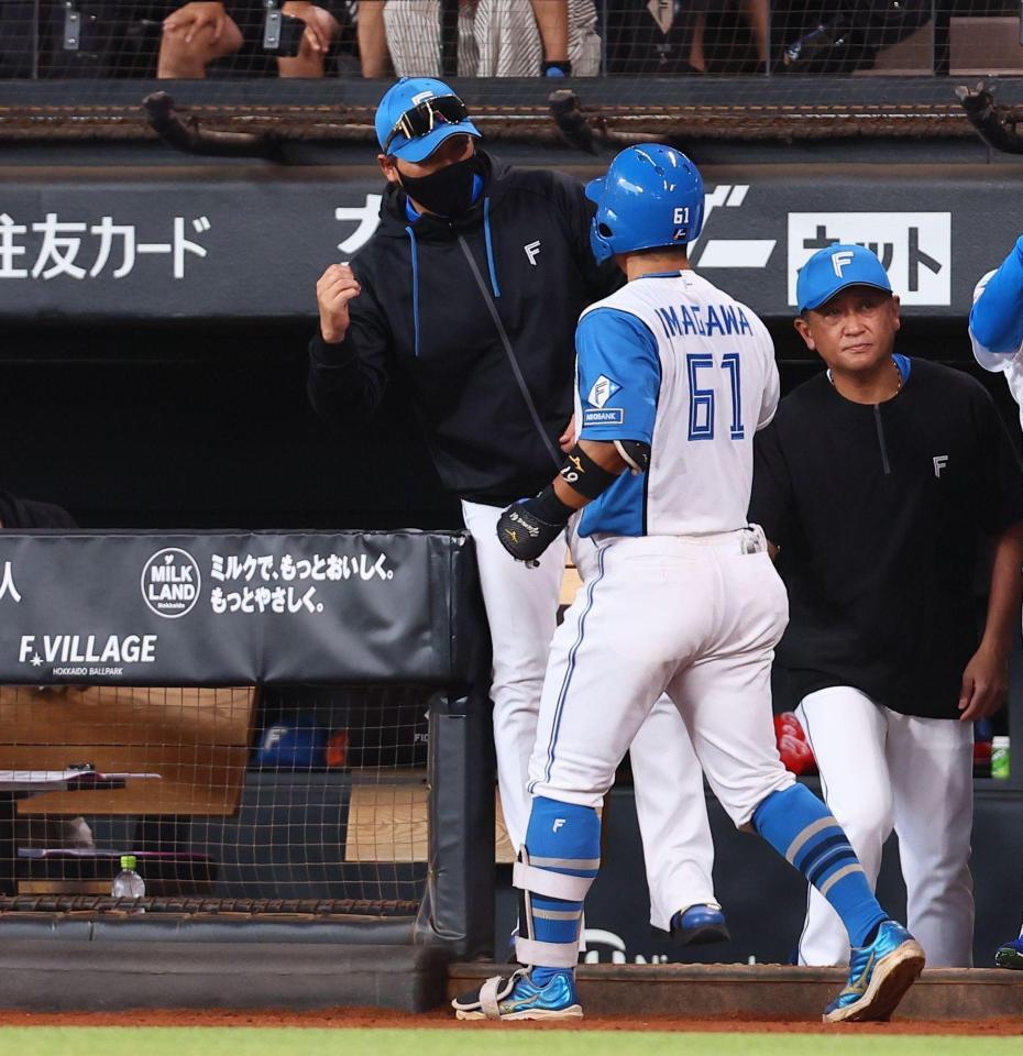 ５回、３ランを放った今川（６１）を迎える新庄監督（中央）＝撮影・中島達哉